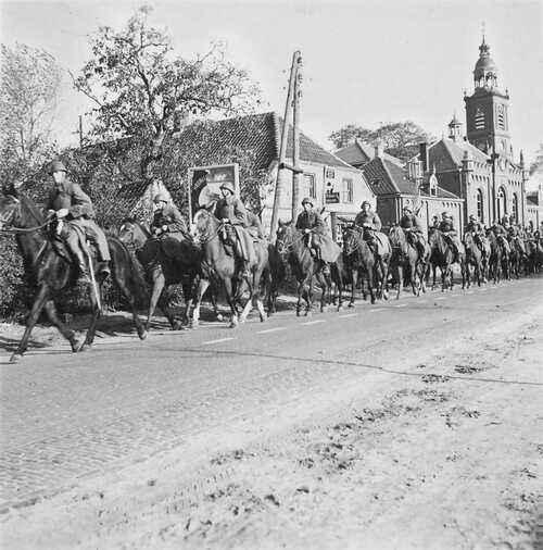 Colonne van circa twintig gewapende soldaten te paard in de Dorpsstraat met op de achtergrond de parochiekerk. (Foto: Johan Prinsen, Collectie familie Prinsen, 1939)